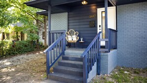 A building with a blue exterior, a set of stairs leading to a door marked with the number 3447, and a chair outside. - {Renovated 2BR in CLT – Where Location, Comfort & Mild Bragging Rights Collide} (Charlotte)