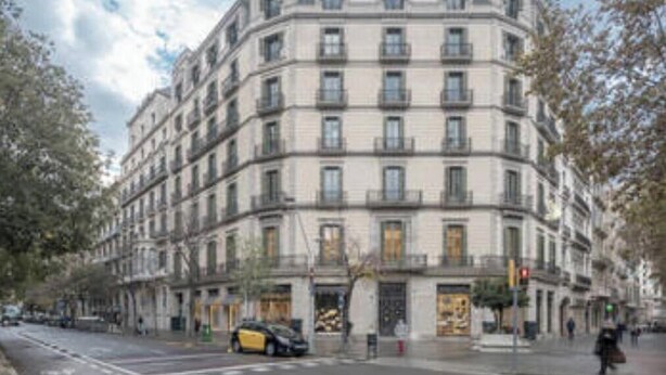 Un immeuble à plusieurs étages doté d’une façade symétrique, de grandes fenêtres et d’une entrée centrale.