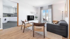 Un appartement moderne comprenant une cuisine, un coin repas et un salon.