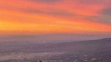 A panoramic view of a valley with a sunset sky.