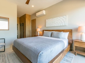 A bedroom with a wooden bed frame, a large window, and a wall-mounted air conditioner.