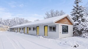 Motellissa on rivi yhden hengen huoneita, joissa jokaisessa on oma ovi ja ikkuna.
