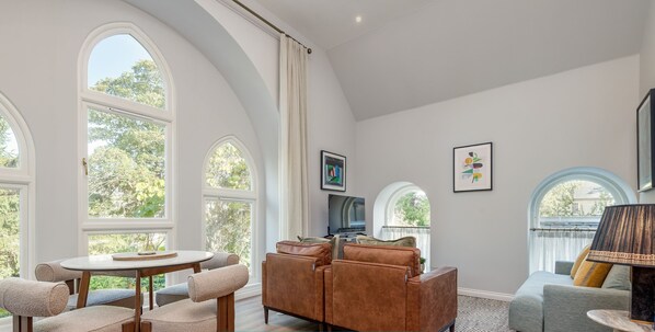A modern living room with a round table, sofas, and a TV.