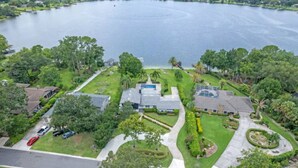 A residential area with a large body of water, houses, and a well-maintained lawn.