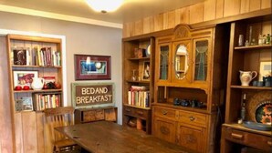 A traditional breakfast room with a wooden table, chairs, and a sign that reads "BED AND BREAKFAST".