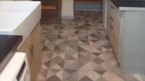 Cocina con microondas, estufa y una escalera que lleva a otra habitación.