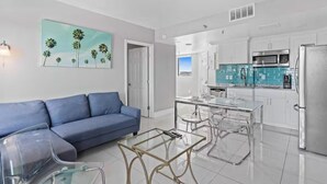 A modern kitchen with white cabinets, a stainless steel refrigerator, and a blue-tiled backsplash. - Modern 2-Bedroom Enclave Condo Retreat (Orlando)