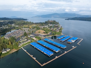 Vue aérienne d’un quartier résidentiel comprenant un port de plaisance, des logements locatifs et une vaste étendue d’eau.