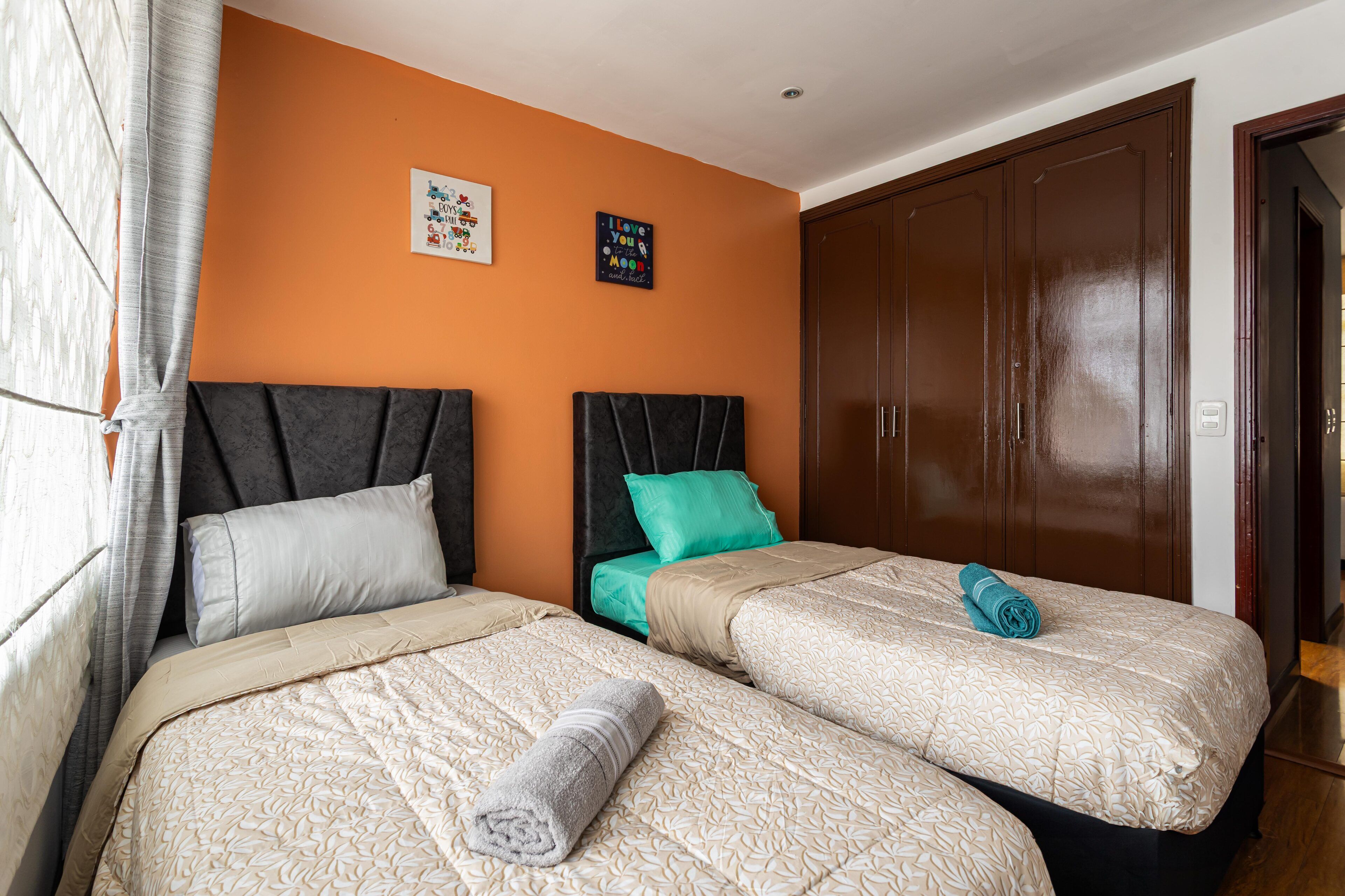 Ein Hotelzimmer mit zwei Betten, einem Kleiderschrank und zwei Wandbildern.