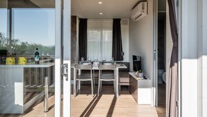 Una cocina moderna con comedor, un separador de vidrio y vistas al exterior.