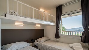 Un dormitorio con dos camas, una ventana con vistas y un balcón.