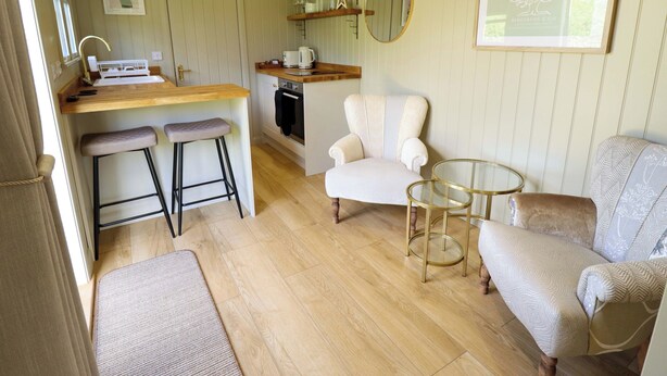 Un espacio habitable compacto con kitchenette, comedor y asientos.