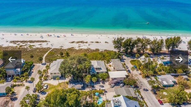 An aerial view of a coastal area with beach, houses, and a clear blue sea. - Mermaid’s Purse~Private Pool! 40 steps to beach! (Anna Maria)