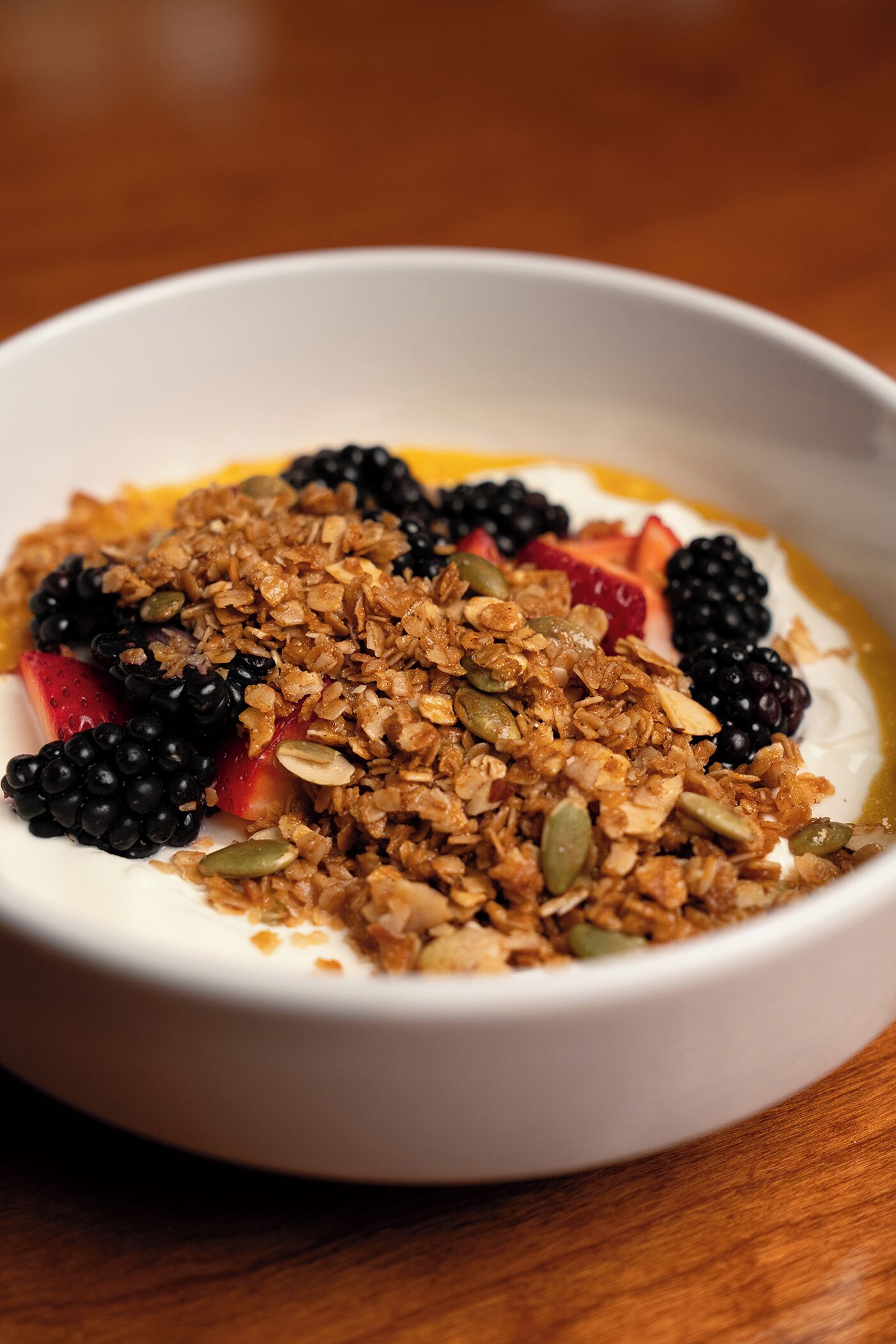 Ein Joghurt mit Granola und einer Mischung aus Beeren.