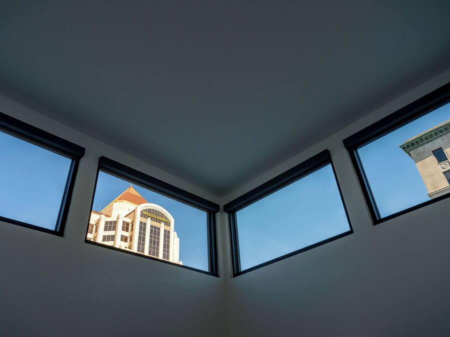 A room with three skylights, each with a clear view of a building with a dome and a sign that reads "Wells Fargo."