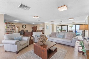 A spacious living room with two sofas, a coffee table, and a bookshelf.