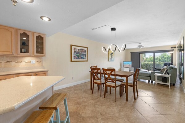 A spacious kitchen with a large island, wooden cabinets, and a dining area with a table and chairs.