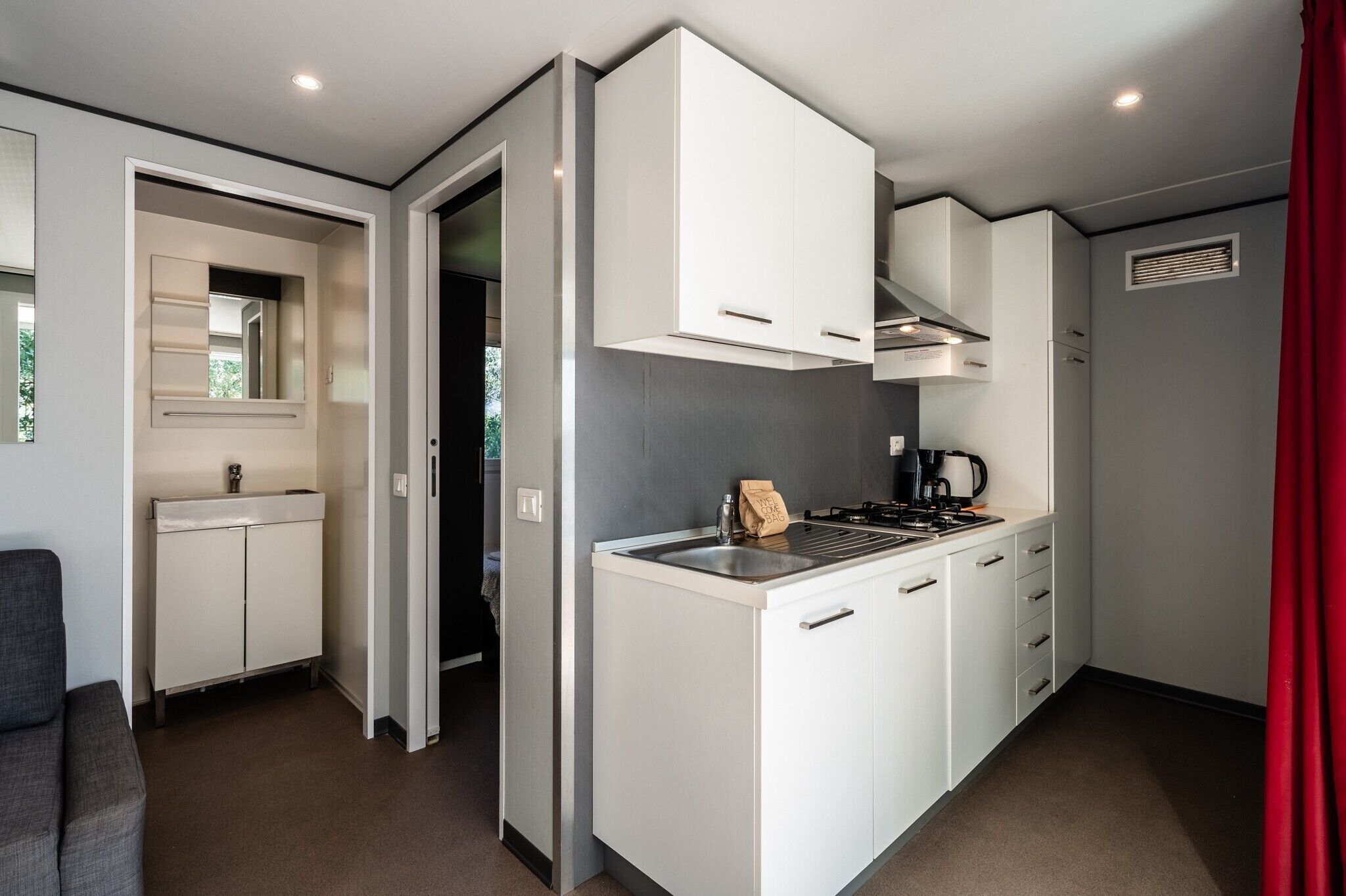A compact kitchen with white cabinets, a gas stove, and a built-in oven.
