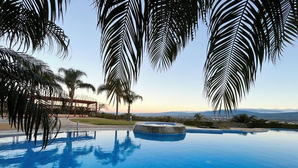 A pool with a circular hot tub, surrounded by palm trees and a gazebo. - Brand New lake view Penthouse with A/C, pool, gym, tennis in common area (Río Oro)