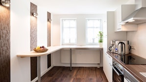 A modern kitchen with a wooden countertop, built-in appliances, and a window with a view. - High-quality, centrally located apartment in the middle of the city (Rudolstadt)