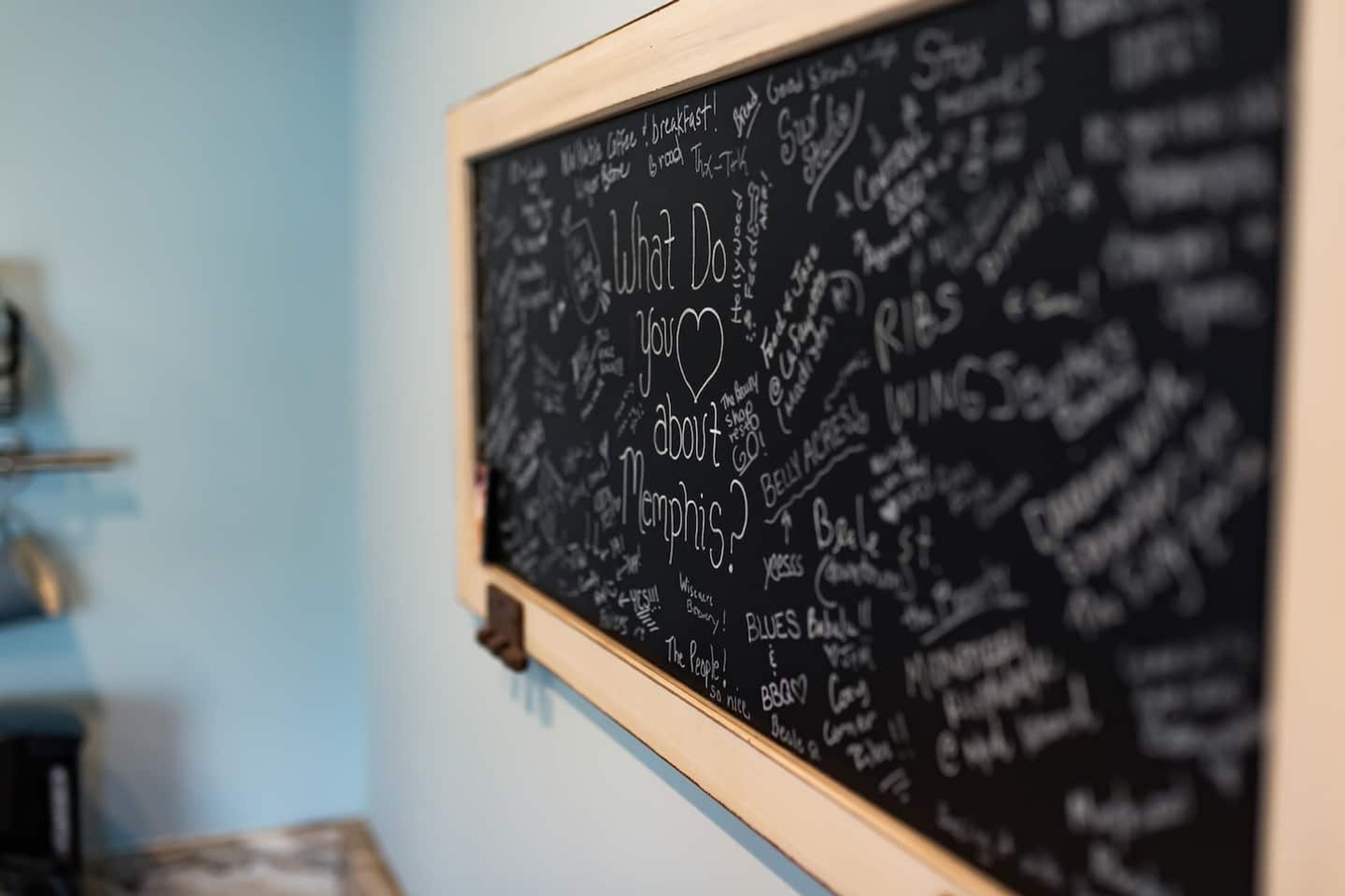 A blackboard with various writings and drawings, including a heart and the word "Memphis".