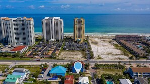 A coastal hotel area with multiple high-rise buildings, a parking lot, and a beach. - Days Like This -spacious Home Steps From the Beach (Navarre)