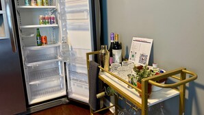 A refrigerator stocked with beverages and a wine cooler with bottles and glasses. - Moody Blues Studio Perfect for Work or Romance (Memphis)