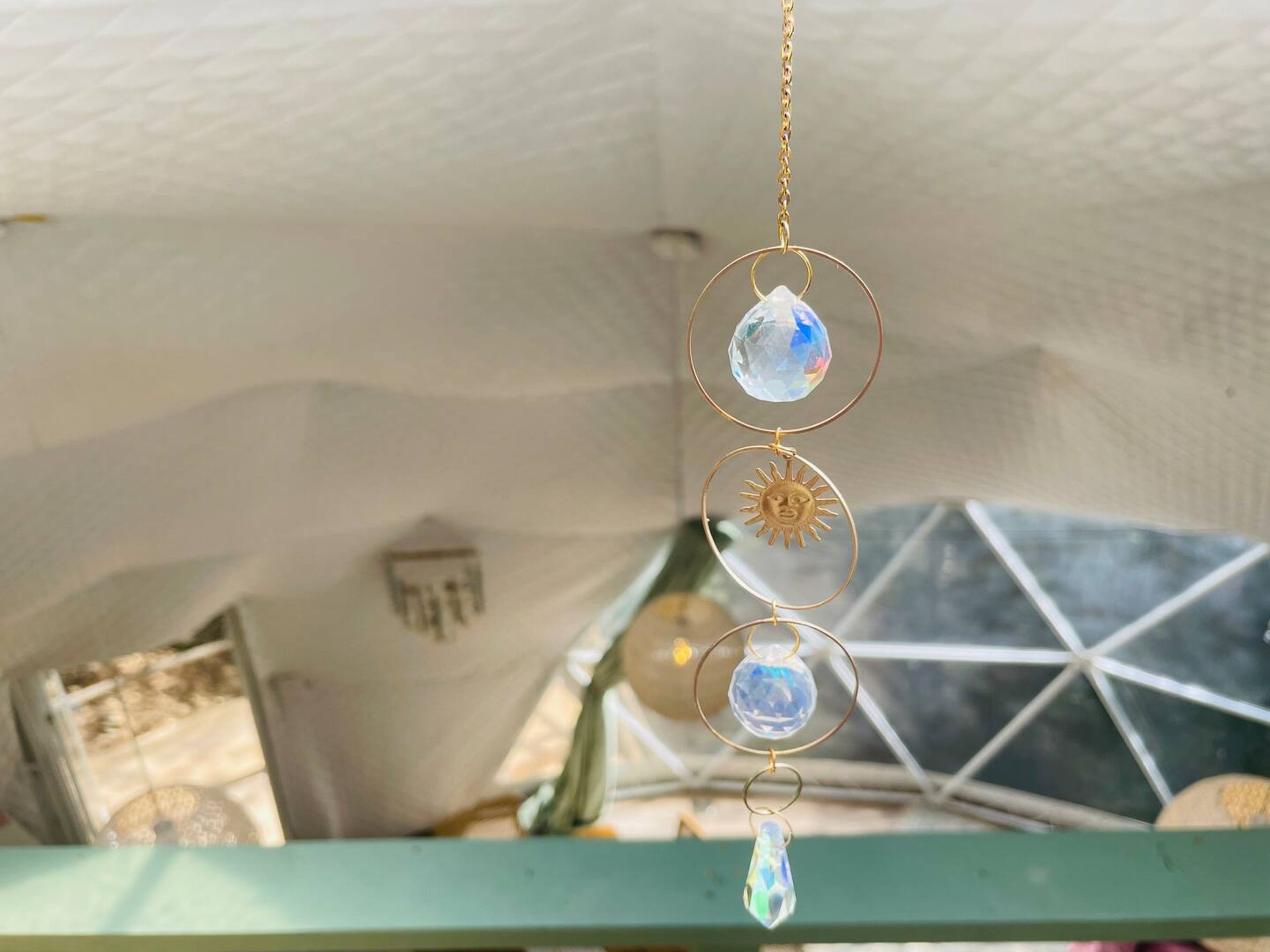 Une chambre avec un lit superposé, un élément décoratif suspendu et un motif géométrique sur le mur.
