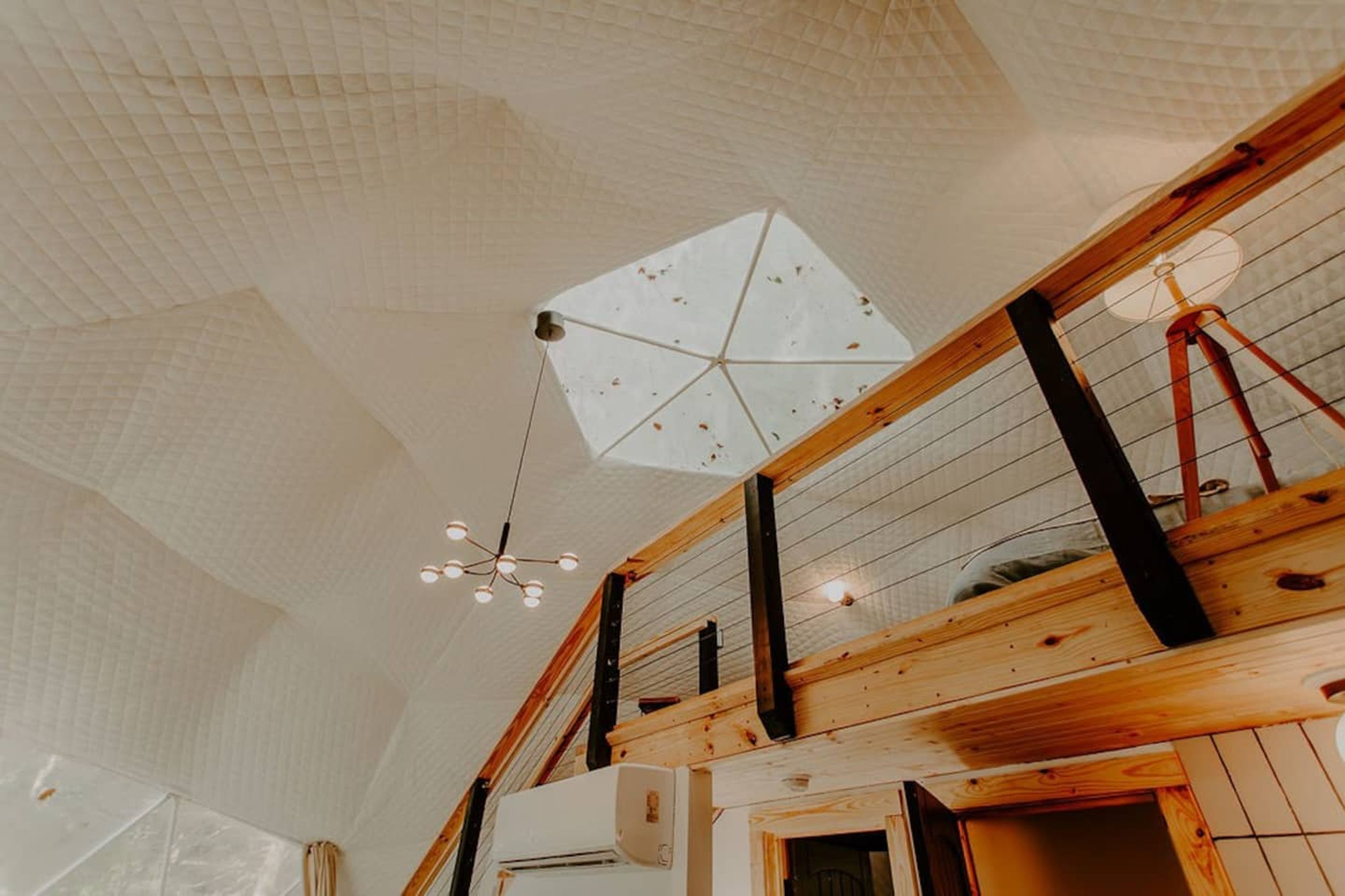 A room with a high ceiling, wooden beams, and a geometric patterned ceiling.