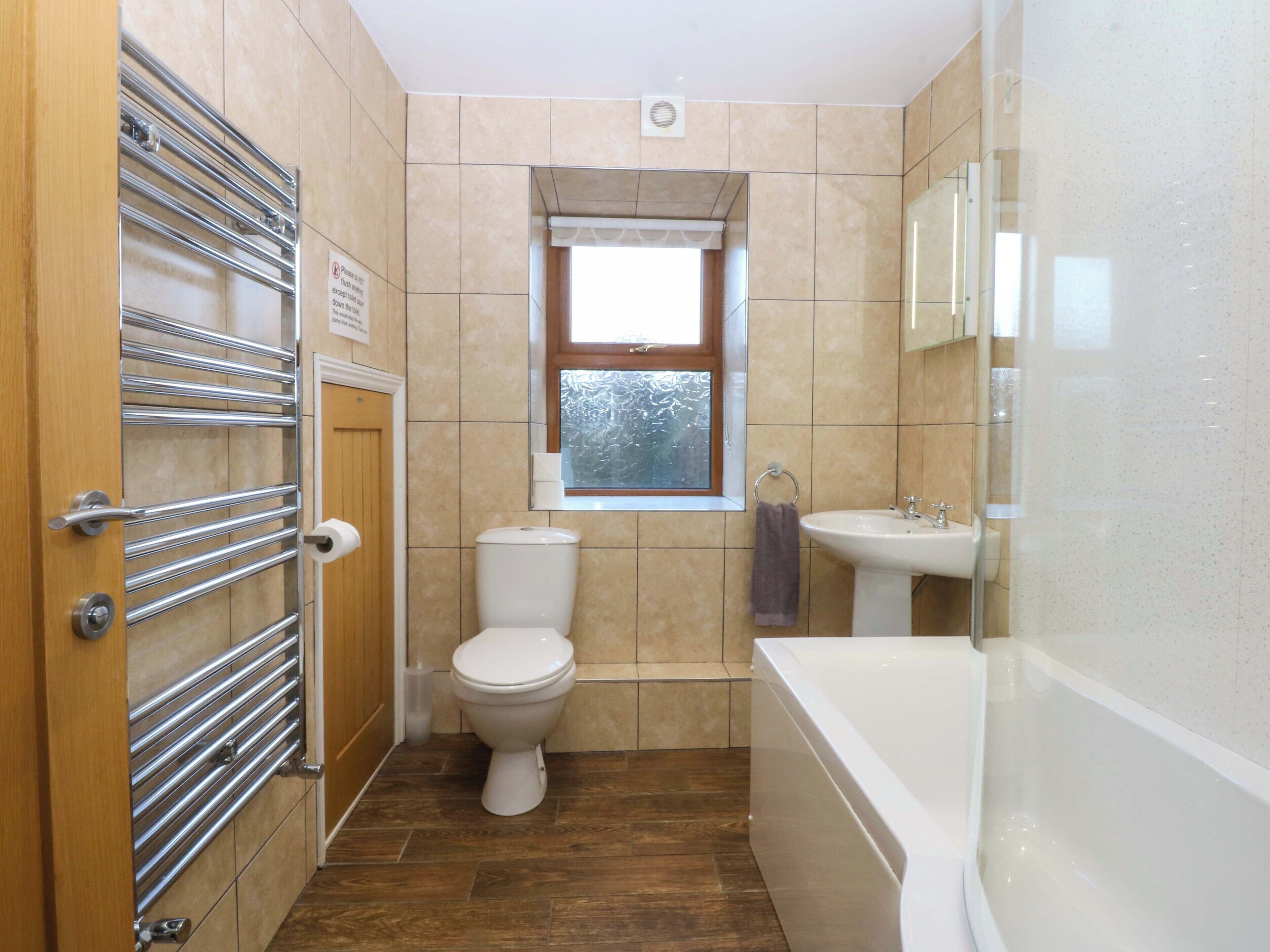 A bathroom with a toilet, sink, and bathtub.
