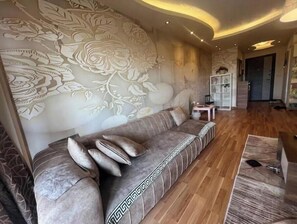 Un salon moderne avec un canapé, un mur orné de motifs et un plancher en bois.