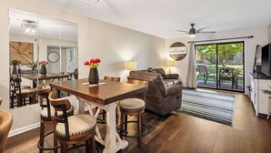 Una sala moderna con comedor, sofá y ventilador de techo.