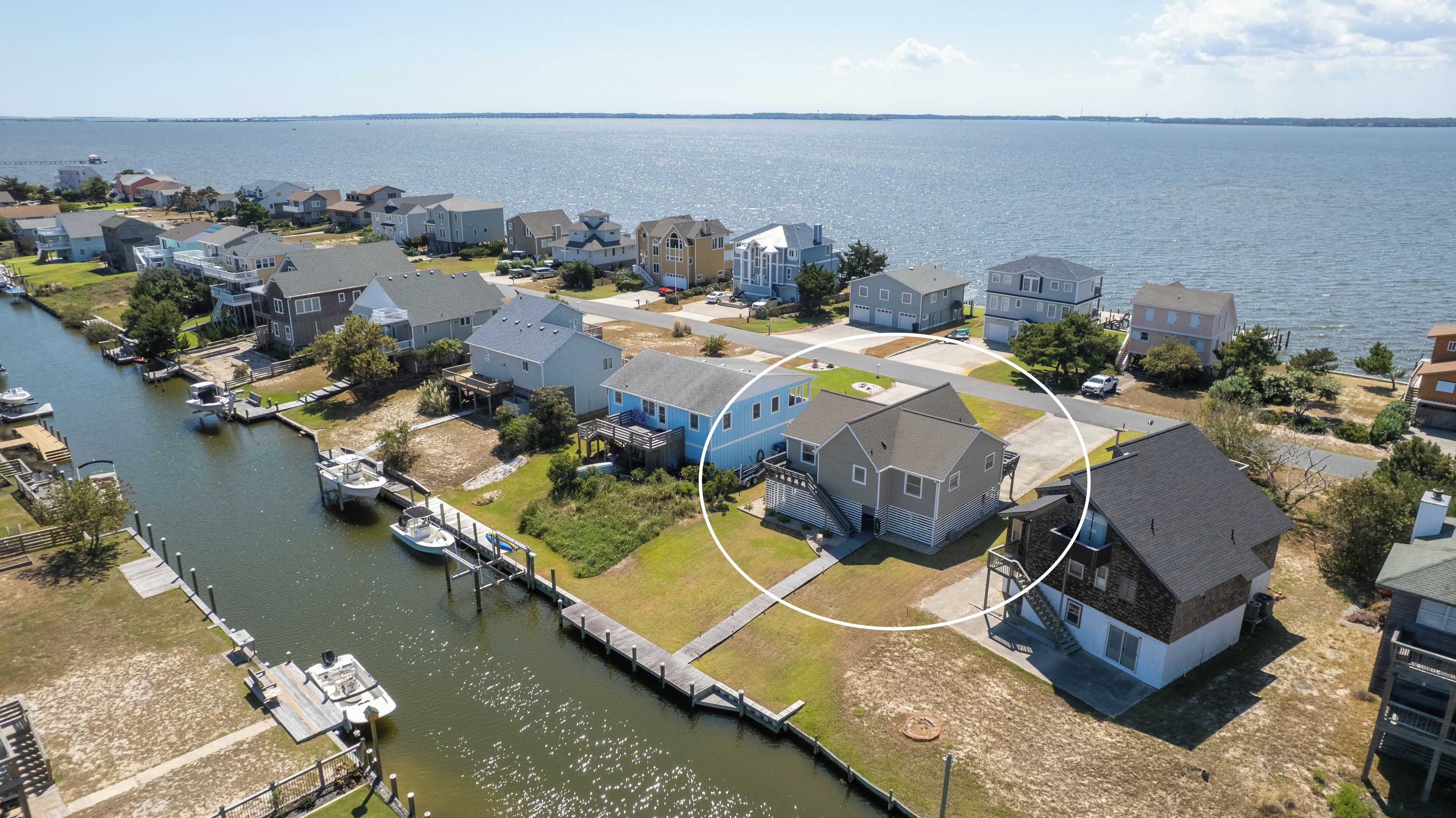 Um bairro residencial com casas à beira-mar, cais e um barco.