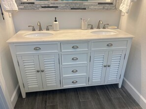 A bathroom with a double sink vanity, two drawers, and a mirror above the sink. - Spacious, Completely Renovated 3BR Keys Getaway By John Pennekamp & Restaurants (Key Largo)