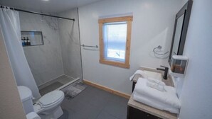 Un baño moderno con ducha, inodoro y lavabo.