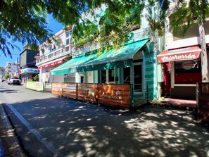Straßenansicht mit einem Restaurant namens 'El Pescador' und einem Geschäft mit einer roten Markise.