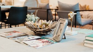 Une table ornée d’un bol décoratif, d’un cadre photo et d’une petite sculpture.