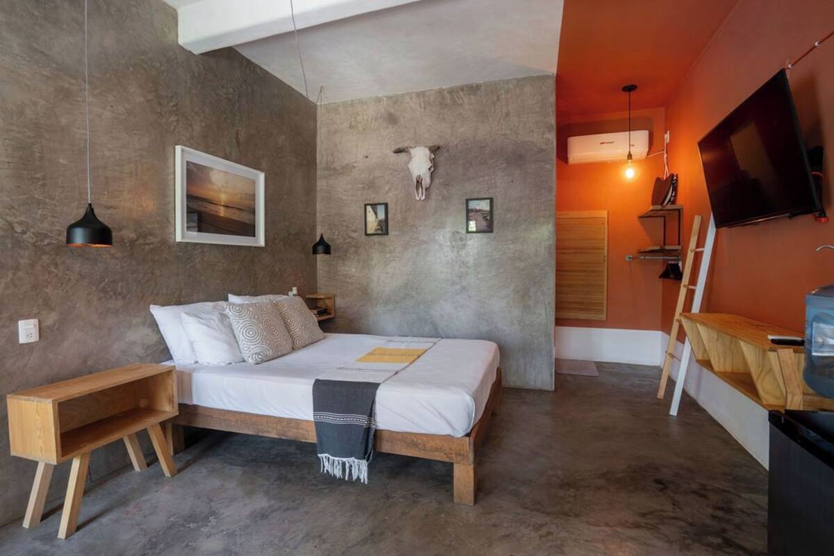 A bedroom with a wooden bed, a skull decoration on the wall, and a TV mounted on the wall.
