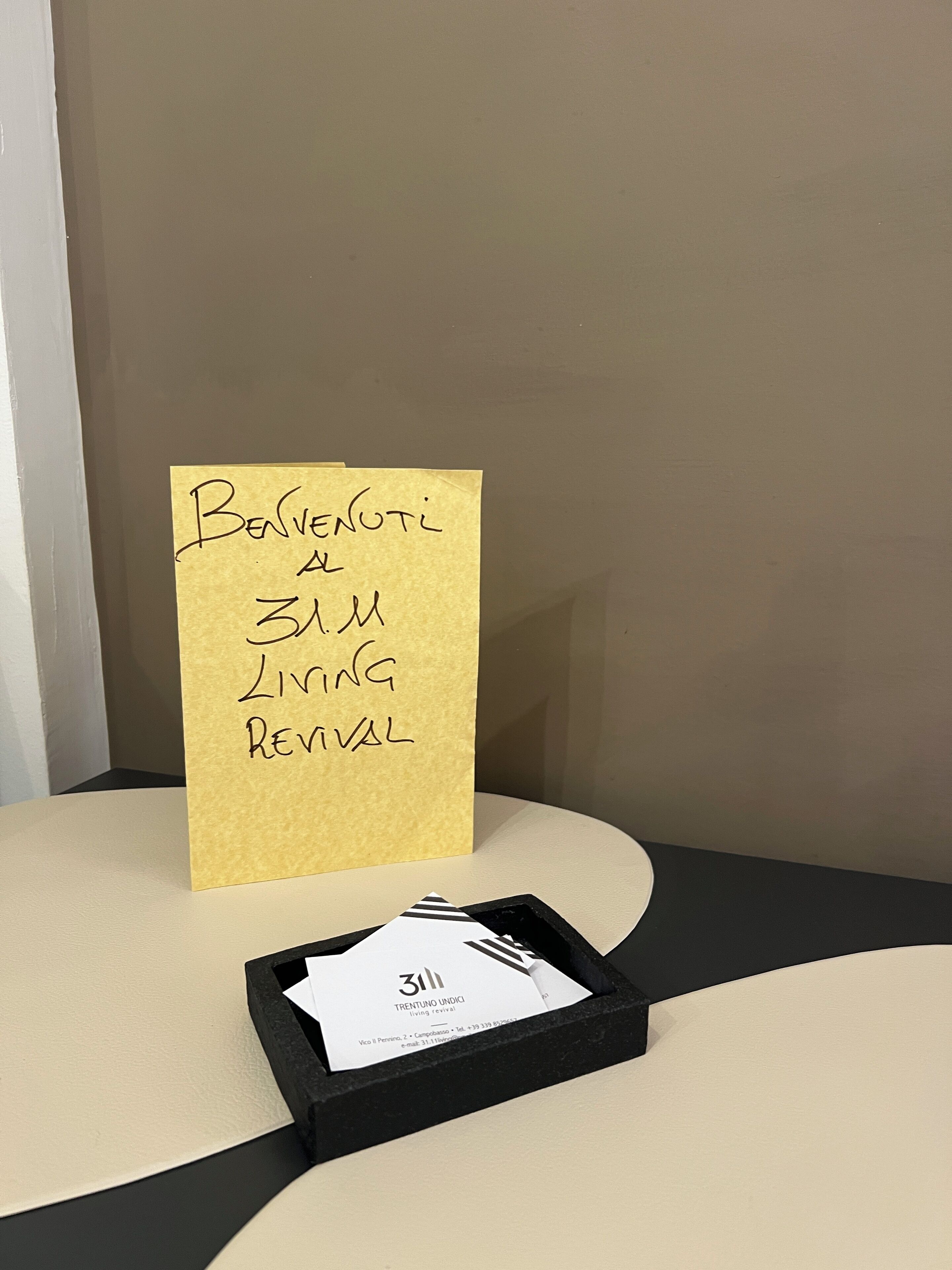 En gul seddel på en væg med teksten "Benvenuti al 3M Living Revival".