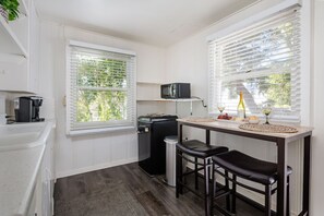 Frigorífico, microondas, cafetera o tetera y mesa de comedor