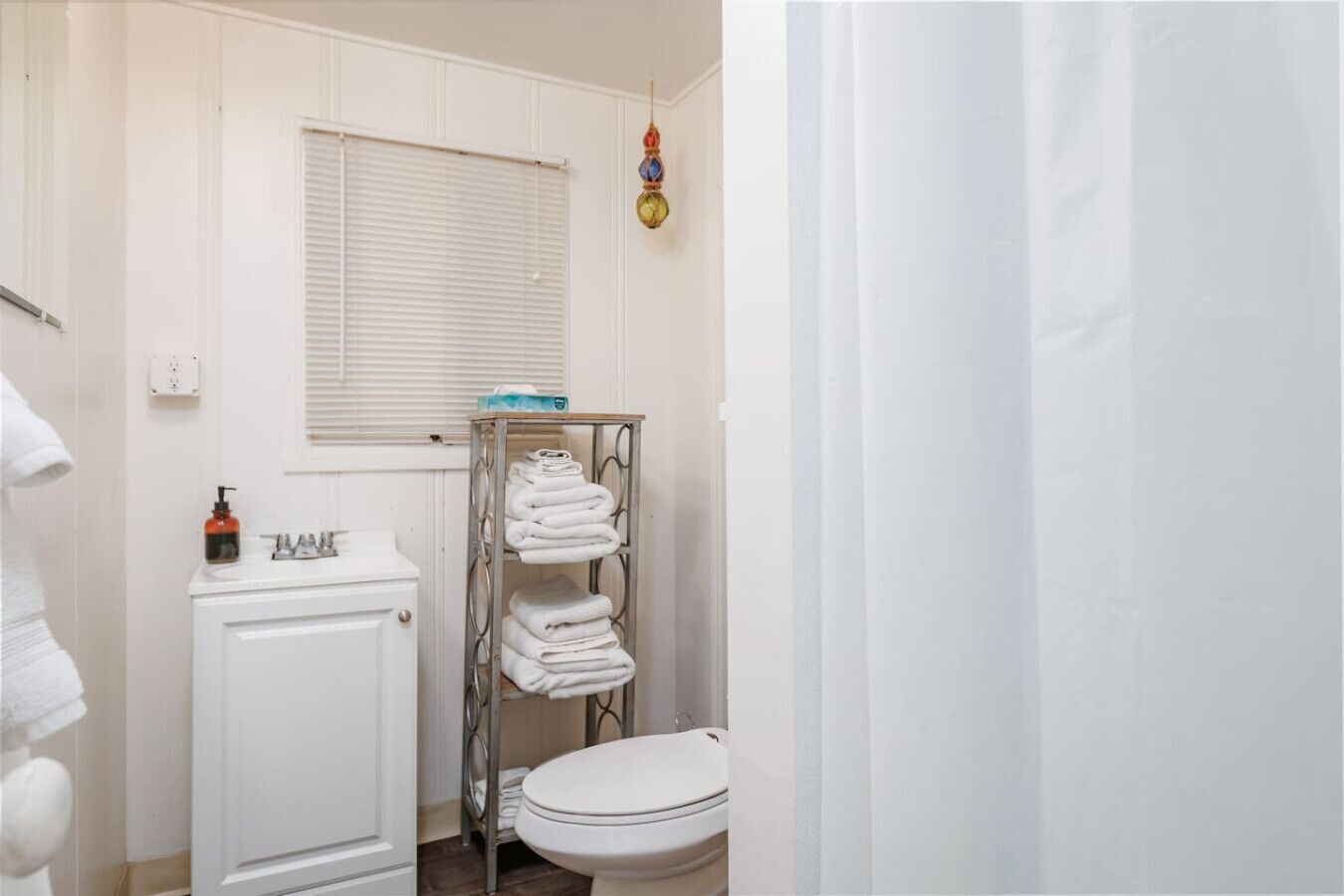 Een kleine badkamer met toilet, wastafel en handdoekhouder.