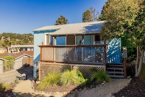A two-story house with a balcony, a small garden, and a clear view of the surrounding neighborhood.