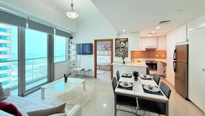 Un appartement moderne comprenant un coin repas, une cuisine et un salon.