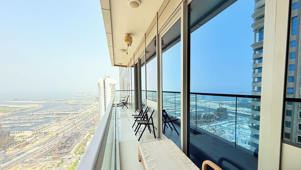 Un balcon offrant une vue sur le paysage urbain et sur des étendues d’eau.