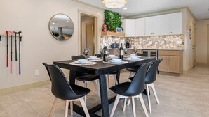 A dining area with a rectangular table set for four, surrounded by black chairs with wooden legs. - Private Heated Pool/Waterfront/5-mins to Beach (Largo)