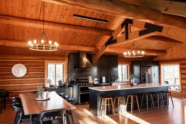 A log cabin interior with a kitchen, dining area, and bar.