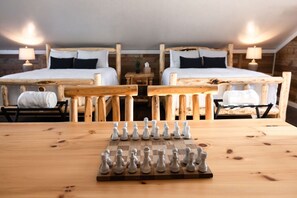 A room with two beds, a wooden table with a chessboard, and two lamps. - Canyon Hideout at Devils Tower (Moorcroft)