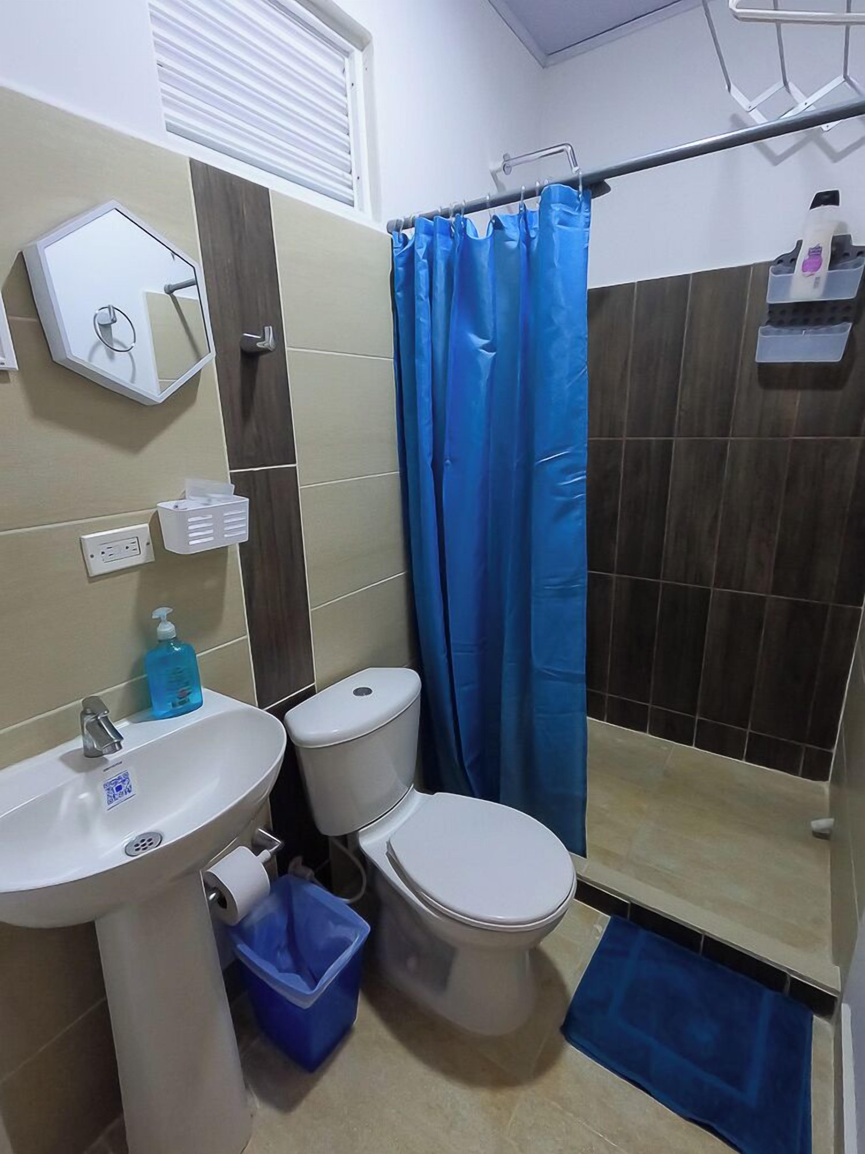 Une salle de bain équipée d’un lavabo, de toilettes et d’un rideau de douche.