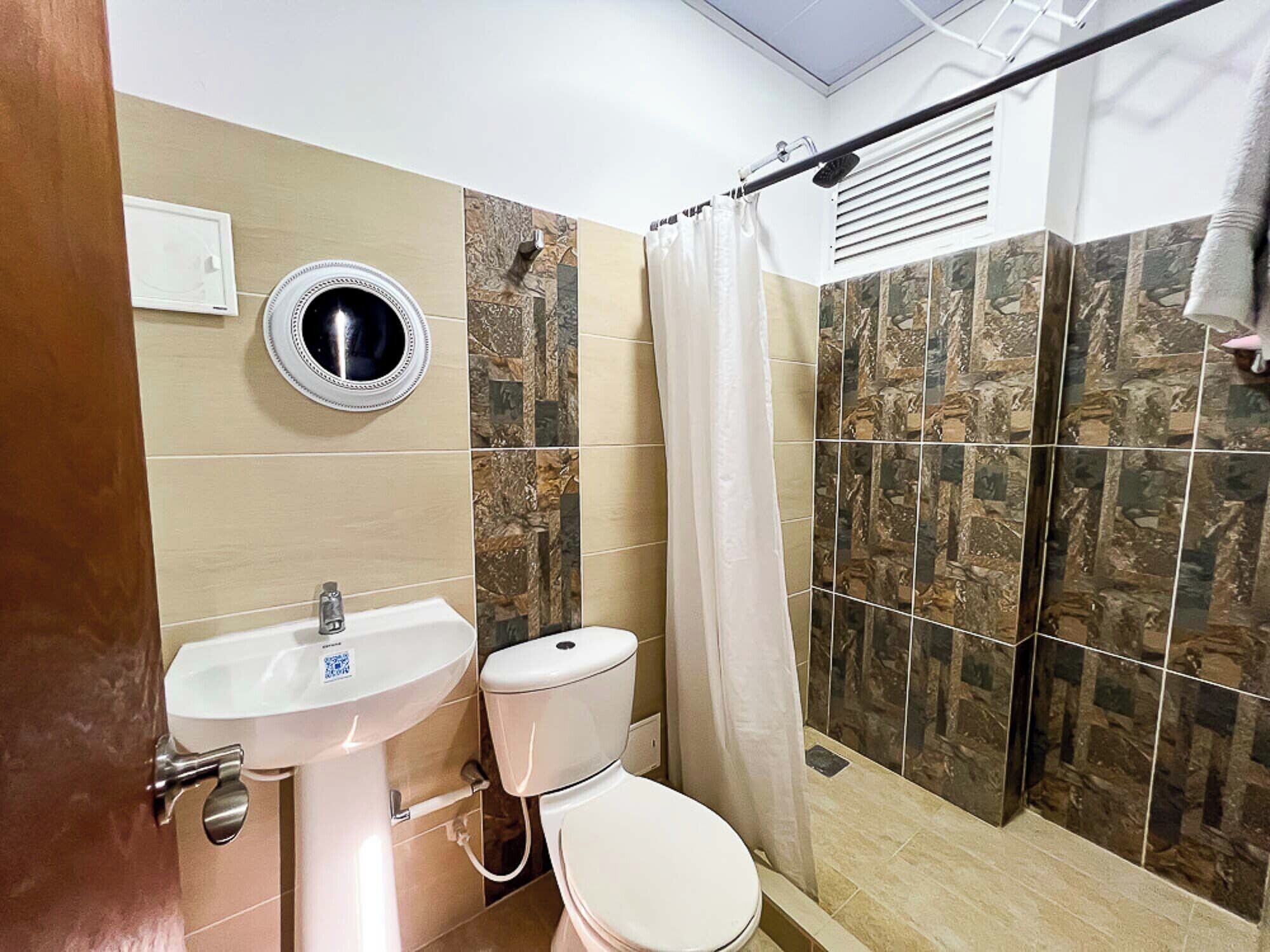 A bathroom with a sink, toilet, and shower.