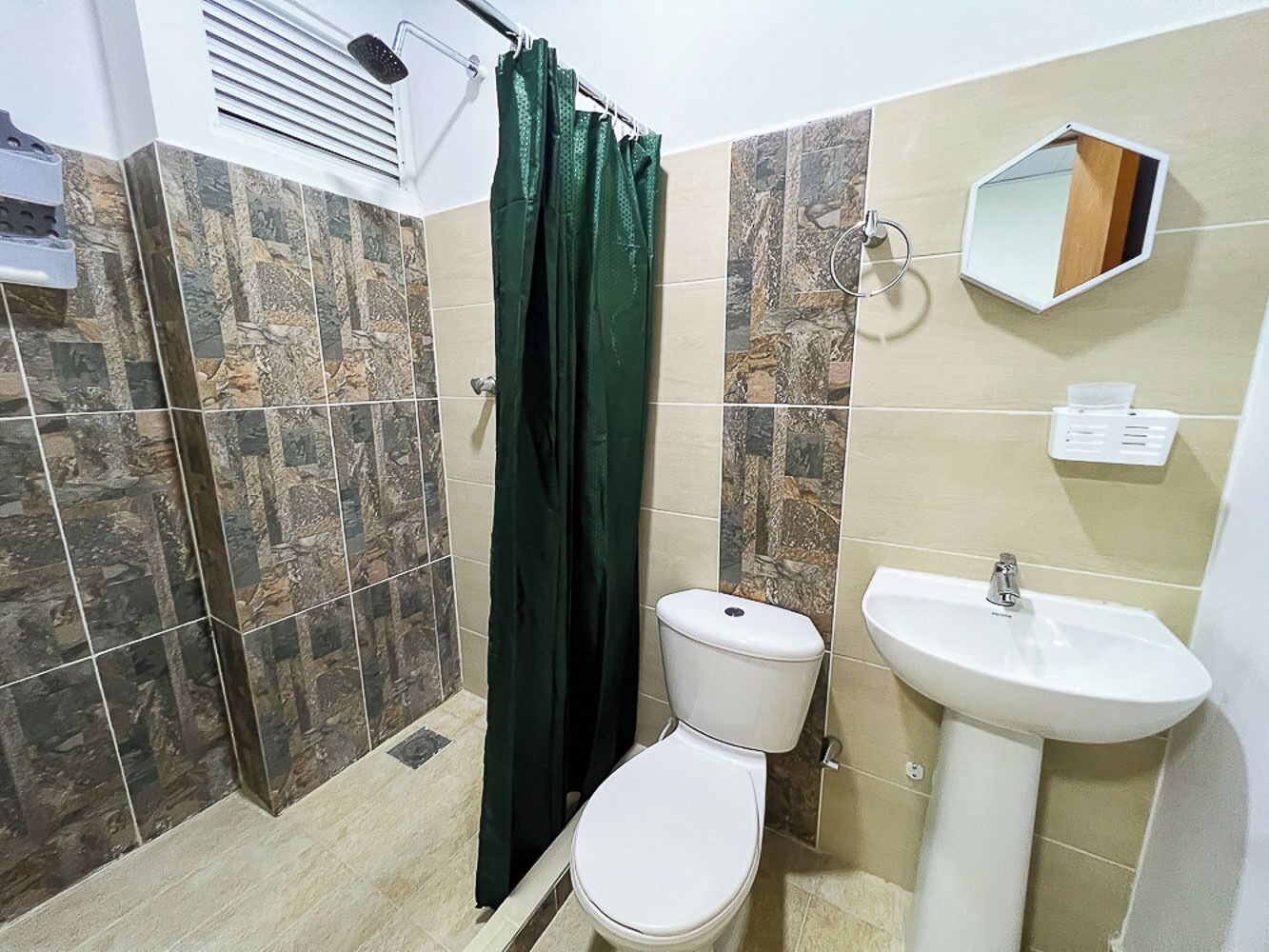 Un bagno con servizi igienici, lavandino e tenda per la doccia.